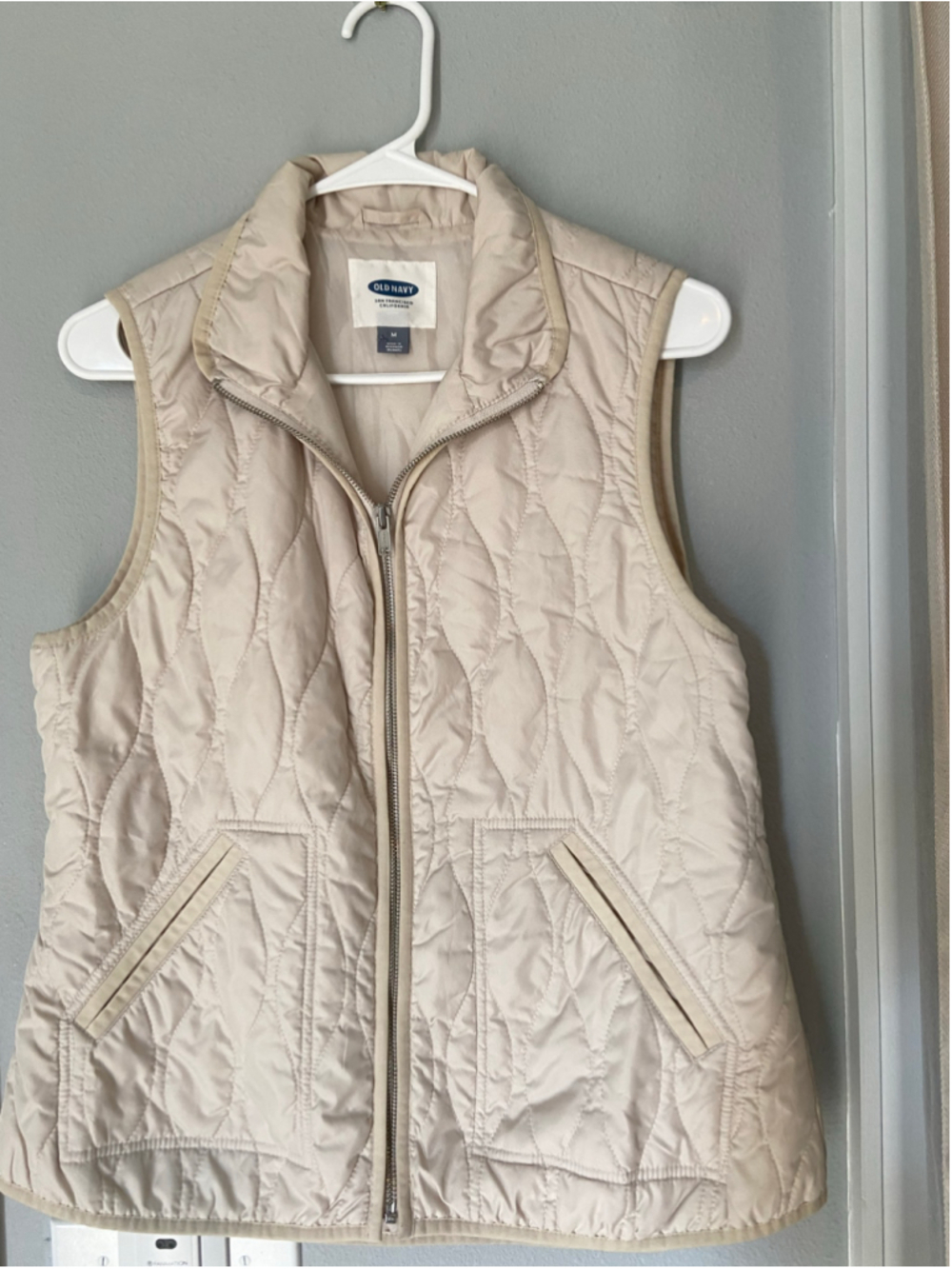 Cute cream colored puffer vest with two front pockets, size medium